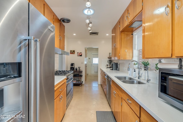 kitchen featuring a sink, stainless steel appliances, light countertops, decorative backsplash, and concrete flooring