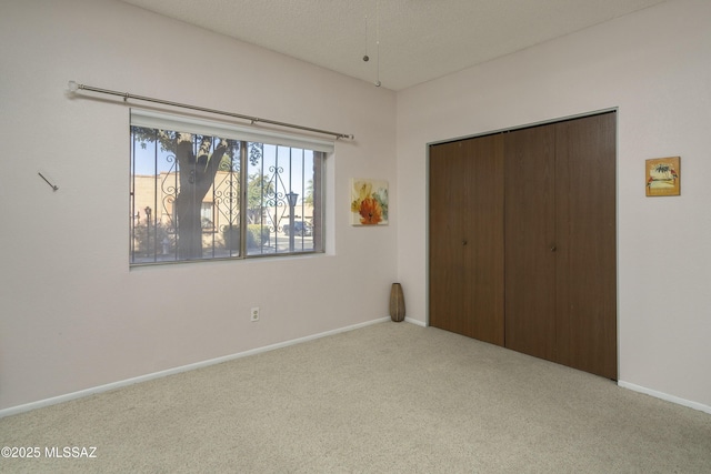 unfurnished bedroom featuring carpet, baseboards, and a closet