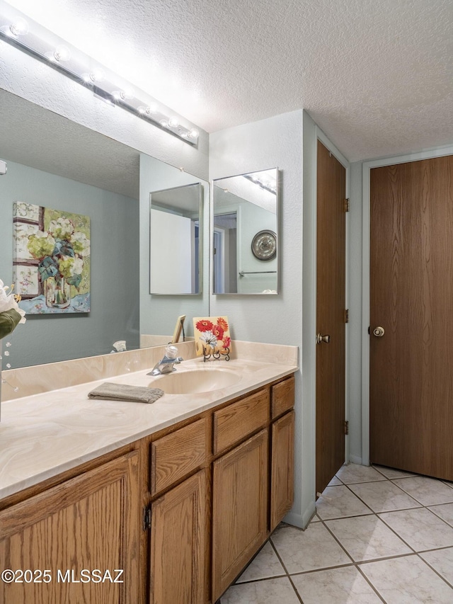 bathroom featuring tile patterned flooring, a textured ceiling, and vanity