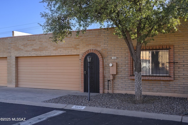 view of front of home with a garage, driveway, and brick siding