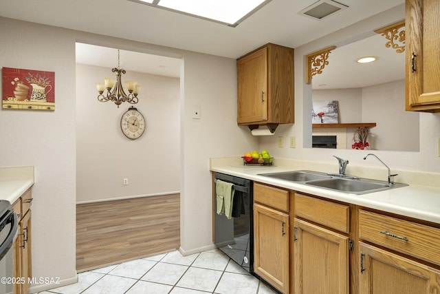 kitchen with light tile patterned flooring, a sink, visible vents, light countertops, and dishwasher