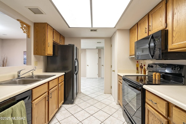 kitchen featuring light countertops, visible vents, a sink, and black appliances