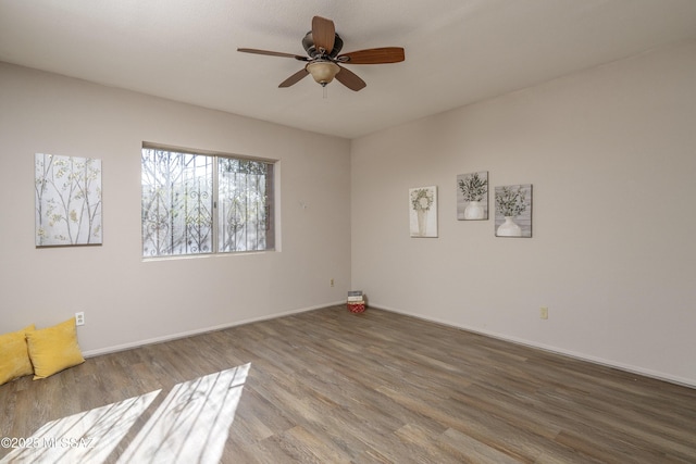 spare room with ceiling fan, baseboards, and wood finished floors