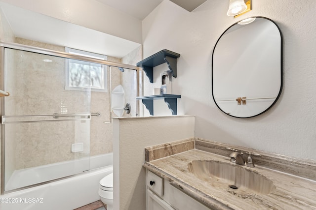 full bathroom featuring vanity, toilet, and combined bath / shower with glass door