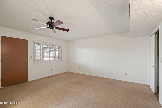 unfurnished bedroom featuring ceiling fan, light carpet, and a textured ceiling