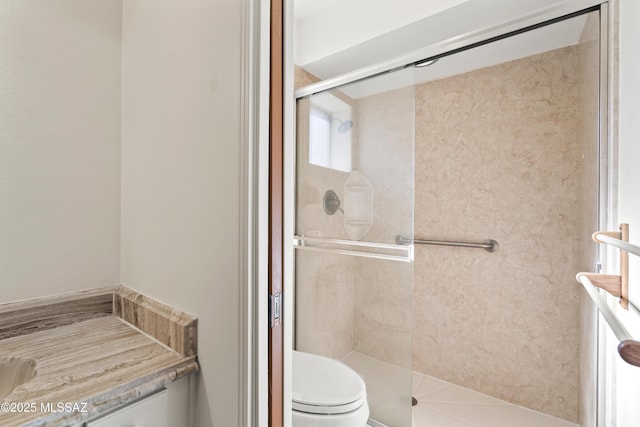 bathroom with a shower with shower door and toilet