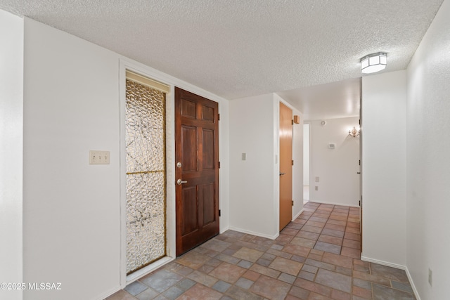 foyer entrance with a textured ceiling