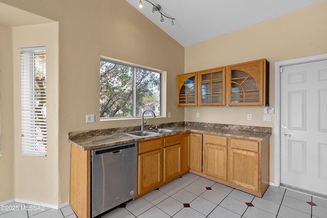 kitchen with sink, stainless steel dishwasher, light tile patterned floors, and lofted ceiling