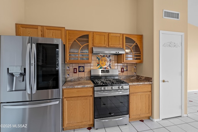 kitchen featuring light tile patterned floors, stainless steel appliances, and tasteful backsplash