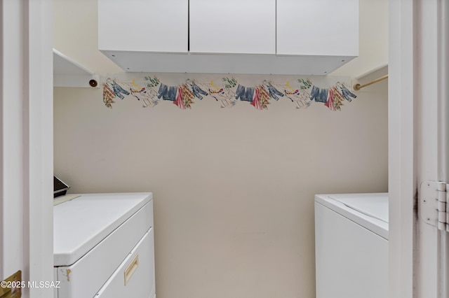 laundry area with washer and dryer and cabinets