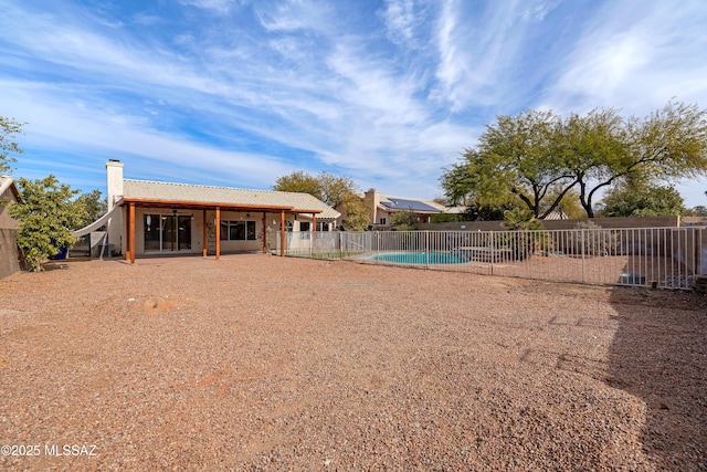 back of house with a fenced in pool and a patio area