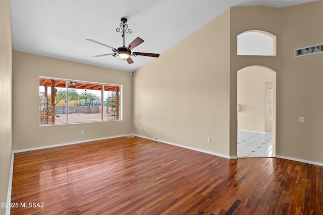 spare room with wood-type flooring, vaulted ceiling, and ceiling fan