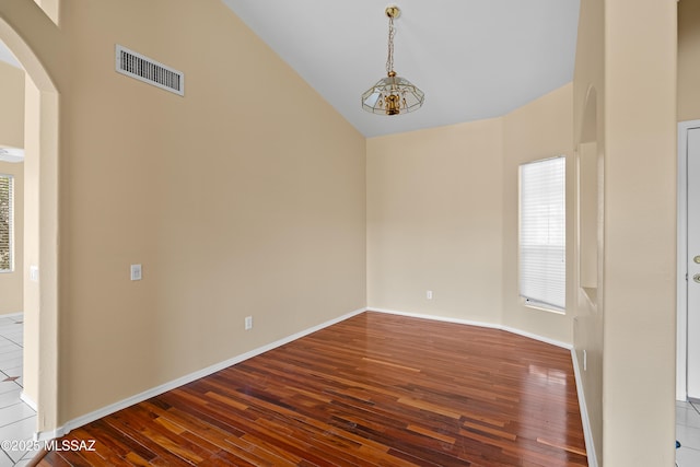 unfurnished room featuring high vaulted ceiling and hardwood / wood-style floors