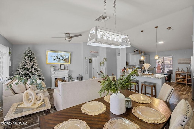 dining area with ceiling fan, dark hardwood / wood-style floors, and lofted ceiling