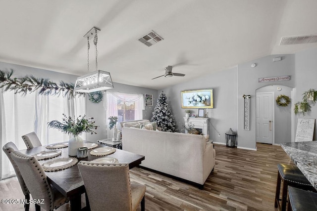 dining area featuring ceiling fan, dark wood-type flooring, and vaulted ceiling