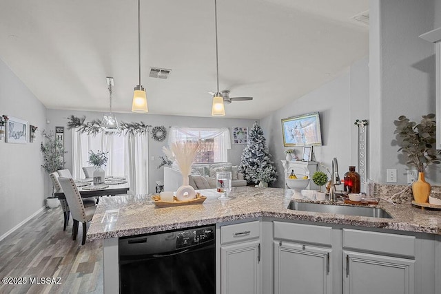 kitchen featuring sink, vaulted ceiling, dishwasher, and pendant lighting