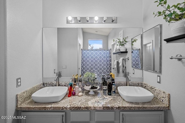 bathroom with curtained shower, vanity, and lofted ceiling