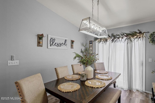 dining space featuring hardwood / wood-style floors and lofted ceiling