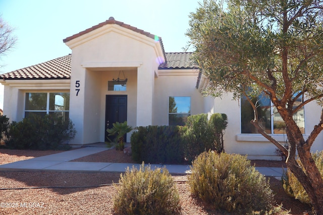 mediterranean / spanish house with a tile roof and stucco siding