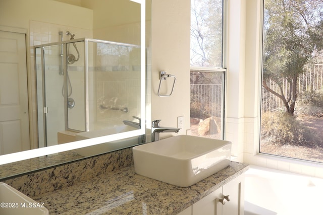 bathroom with a tub to relax in, a stall shower, and vanity