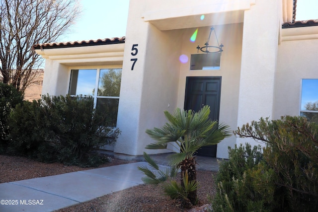 doorway to property with a tiled roof and stucco siding