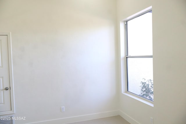 unfurnished room with baseboards