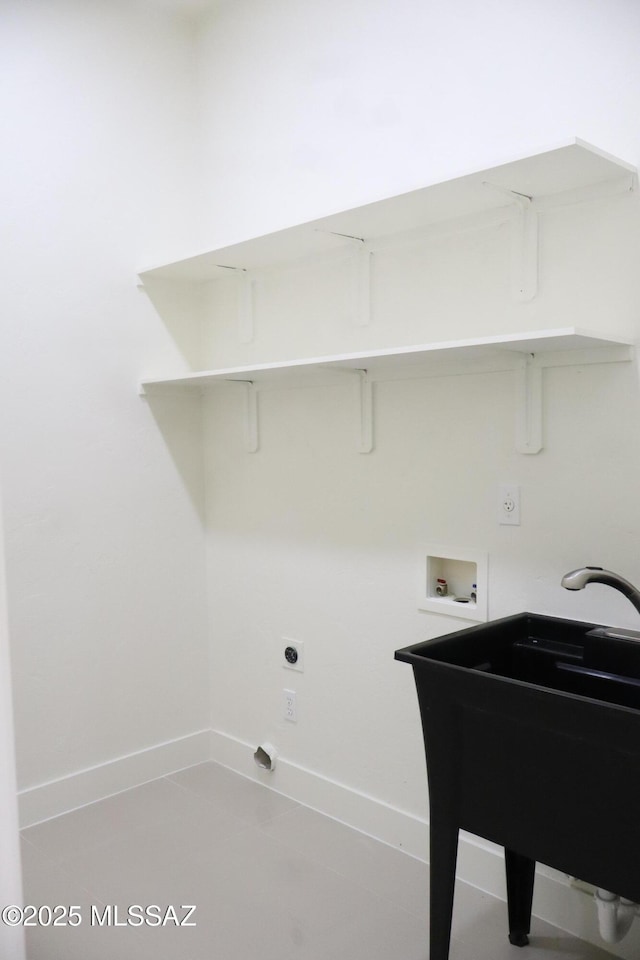 laundry area with laundry area, washer hookup, a sink, and baseboards