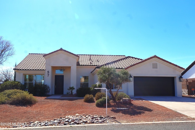 57 Highland Cir, Rio Rico, AZ 85648 - mediterranean / spanish house with a tile roof, concrete driveway, a garage, and stucco siding