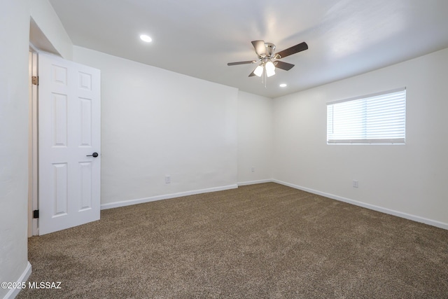 empty room featuring dark carpet and ceiling fan