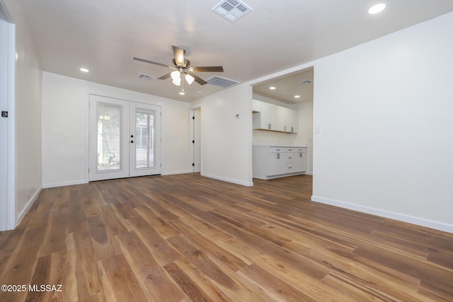 unfurnished living room with dark hardwood / wood-style floors, french doors, and ceiling fan