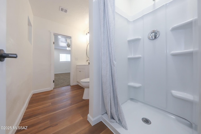 bathroom with wood-type flooring, toilet, a shower with shower curtain, and vanity