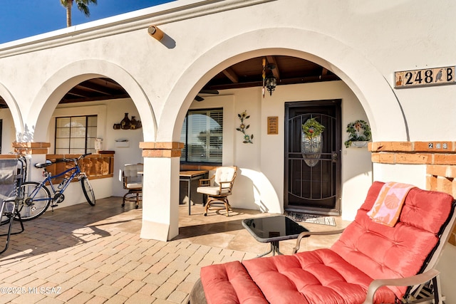 view of exterior entry with a patio area