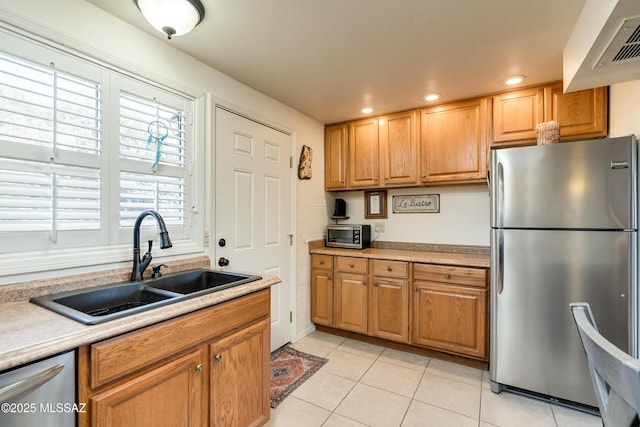 kitchen featuring sink, light tile patterned floors, and stainless steel appliances