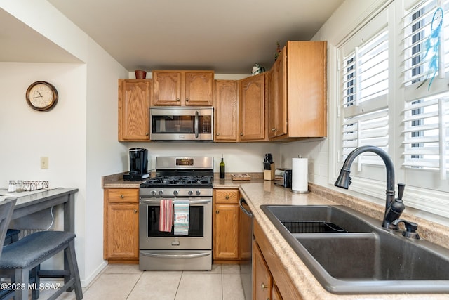 kitchen with sink, stainless steel appliances, and light tile patterned flooring