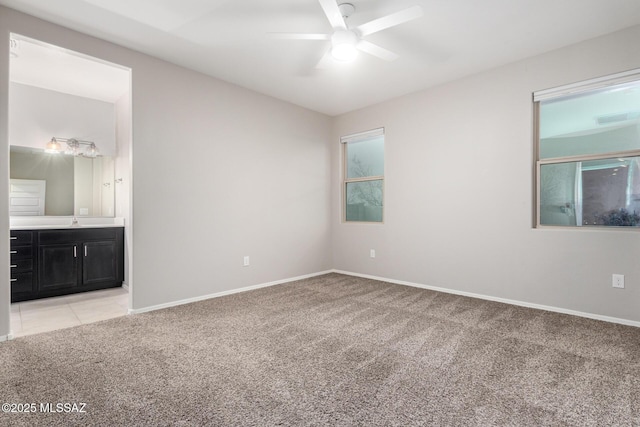 spare room with ceiling fan, light colored carpet, and sink