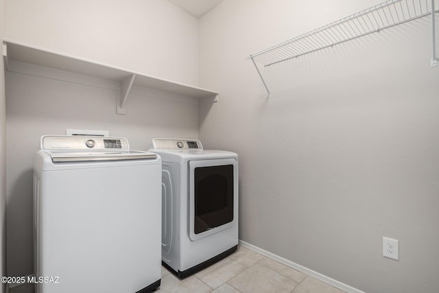 clothes washing area featuring washer and dryer and light tile patterned floors