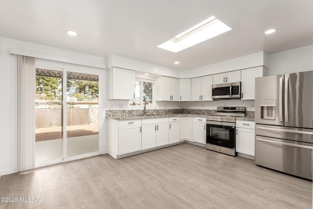 kitchen featuring white cabinetry, stainless steel appliances, and plenty of natural light