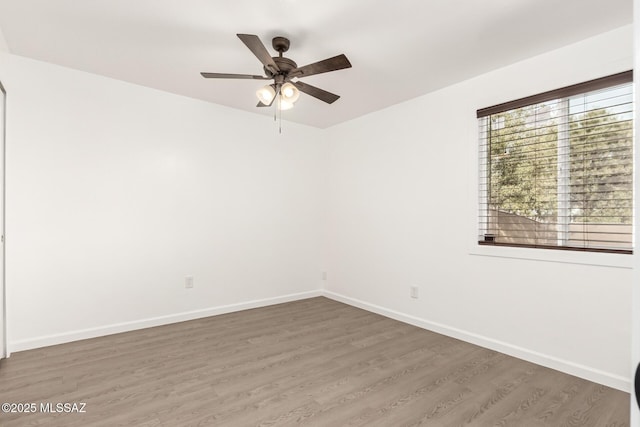 empty room with dark hardwood / wood-style flooring and ceiling fan