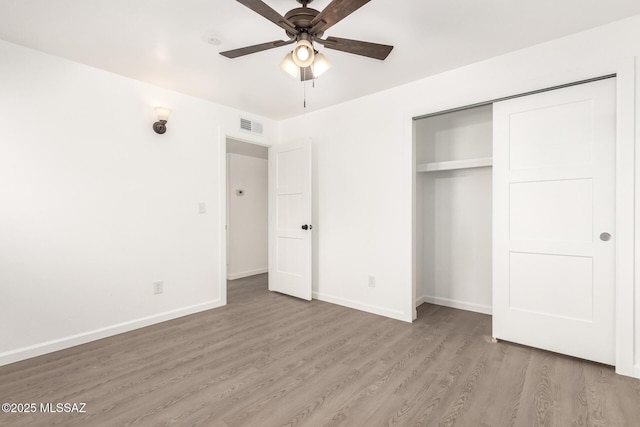 unfurnished bedroom featuring hardwood / wood-style flooring, ceiling fan, and a closet