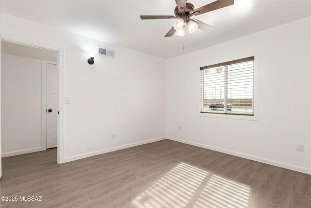 spare room with hardwood / wood-style floors and ceiling fan