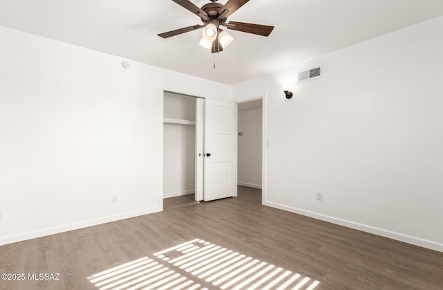 unfurnished bedroom with hardwood / wood-style flooring, ceiling fan, and a closet