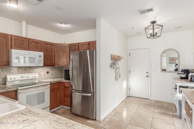 kitchen featuring white appliances, sink, backsplash, hanging light fixtures, and light tile patterned floors