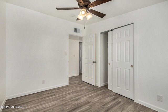 unfurnished bedroom featuring wood-type flooring, ceiling fan, and a closet