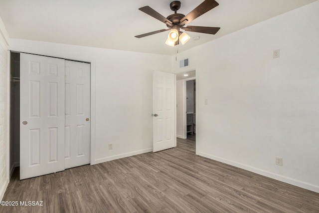 unfurnished bedroom with hardwood / wood-style flooring, ceiling fan, and a closet