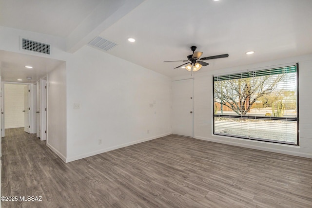 empty room featuring beamed ceiling, ceiling fan, and hardwood / wood-style flooring