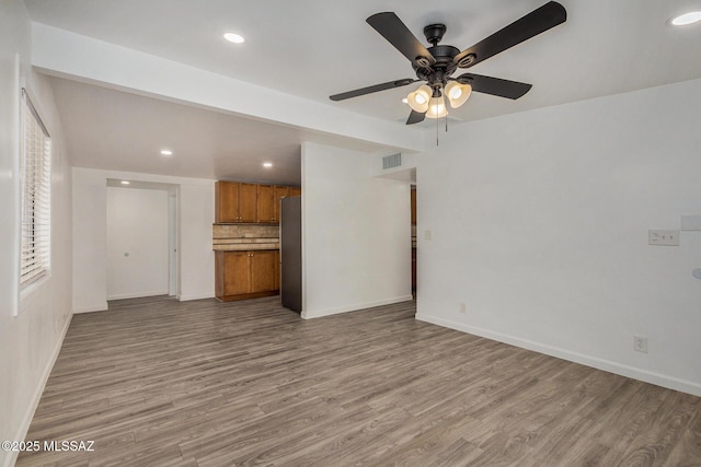 unfurnished living room featuring ceiling fan and light hardwood / wood-style floors