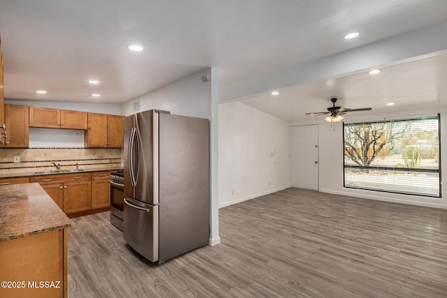 kitchen with hardwood / wood-style floors, sink, decorative backsplash, ceiling fan, and stainless steel appliances