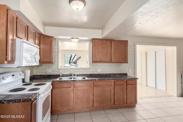 kitchen featuring sink, white appliances, and light tile patterned floors