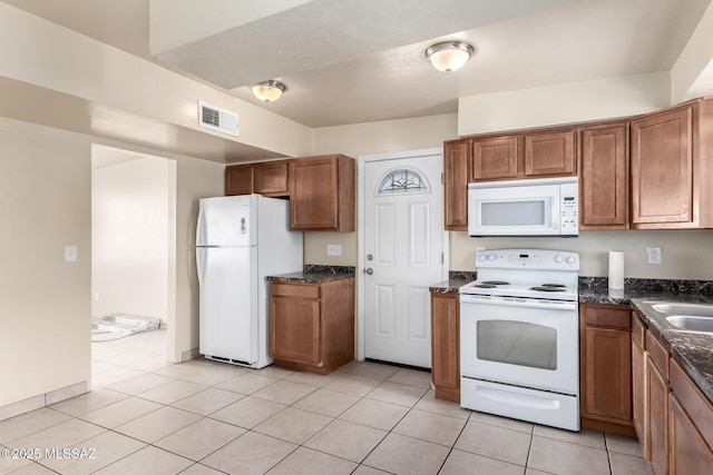 kitchen with white appliances and light tile patterned flooring