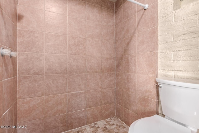 bathroom featuring toilet and tiled shower